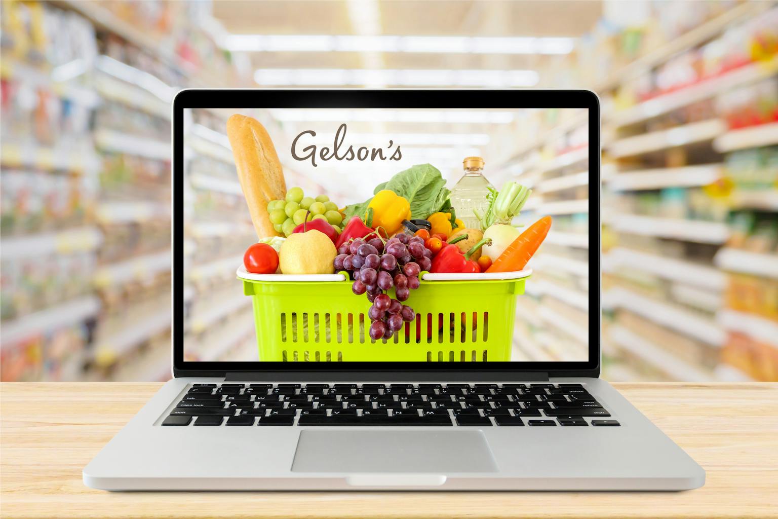 laptop with photo of cart with groceries and Gelson's logo background is blurred grocery store aisle